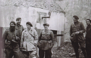 Ligne Maginot - MONTGENEVRE (BARRAGE RAPIDE) - (Blockhaus pour arme infanterie) - Félicitations de l'équipage par les Lt Col Brasset (Gouverneur militaire de Briançon) et Maury (Chef de corps du 154° RAP) pour leur résistance face aux Italiens.
L'AC Gertain (2ème sur la droite) et une partie de l'équipage sont visibles sur le cliché.
Noter le faux canon fiché dans un créneau peint sur la façade.