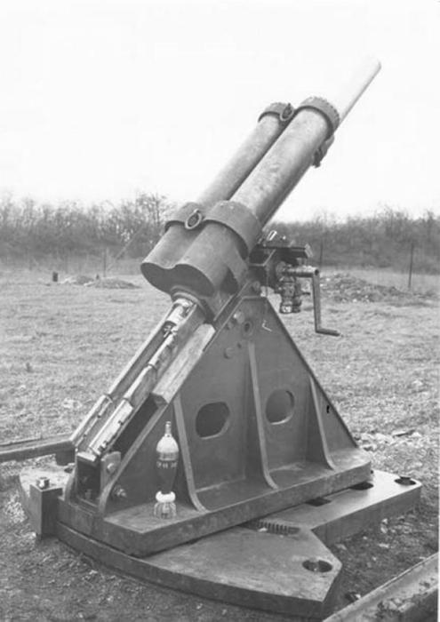 Ligne Maginot - Mortier de 81 mm mle 1932 - Mortier de 81 pour tourelle (commandes de pointage à droite) sur affut de casemate lors des essais du matériel.
Noter la présence d'un obus de 81 mle 32 avec une charge additionnelle posé sur le support.