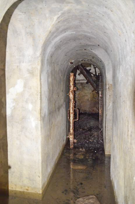 Ligne Maginot - HUTTINGUE OUEST 1 - (Blockhaus pour arme infanterie) - Couloir de liaison entre les deux entrées. Celle du fond est bouchée par des branchages. - P. Lambert & D. Froehly