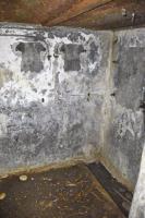 Ligne Maginot - 6M - (Chambre de coupure) - Mur du fond de la chambre. A droite les traces du boitier répartiteur, à gauche les 2 boîtiers de protection pour les lignes de campagne pouvant se raccorder sur la chambre de coupure (2x6 lignes). Au sol un caniveau.
