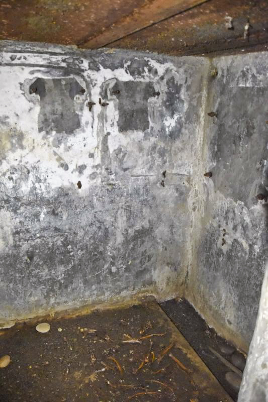 Ligne Maginot - 6M - (Chambre de coupure) - Mur du fond de la chambre. A droite les traces du boitier répartiteur, à gauche les 2 boîtiers de protection pour les lignes de campagne pouvant se raccorder sur la chambre de coupure (2x6 lignes). Au sol un caniveau. - D.Froehly