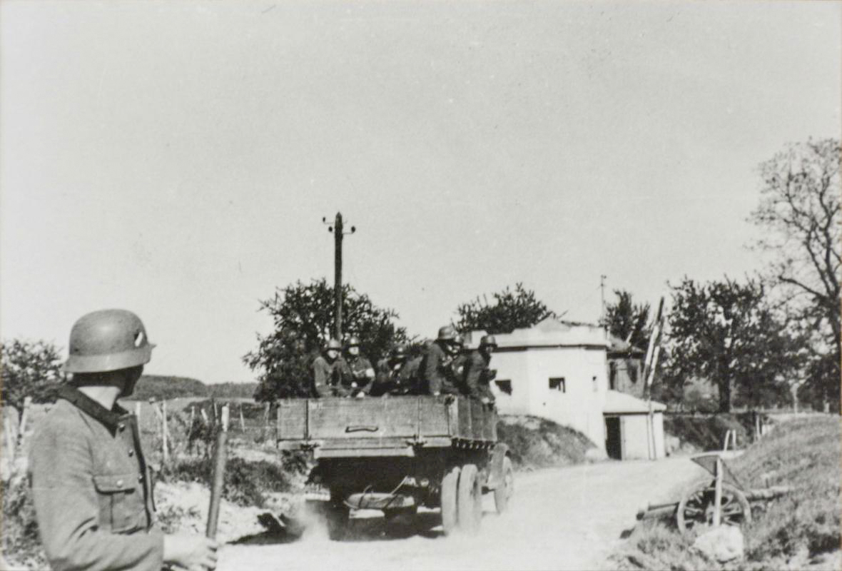 Ligne Maginot - SPICHEREN (MF DE) - (Poste GRM - Maison Forte) - Vue du coté route, les allemands passent devant l'avant poste dont la barrière a été réouverte.
Noter que l'avant poste ne comporte aucune trace de combat et que la partie casernement à l'arrière  est intacte - Inconnu