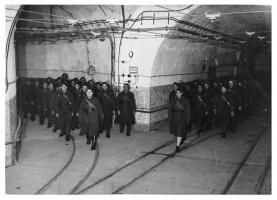 Ligne Maginot - HACKENBERG - A19 - (Ouvrage d'artillerie) - Magasin M1, galerie de sortie des plateformes Péchot vides et accès à la gare principale. Noter la composition particulièrement 'cinématographique' de la photo : une telle arrivée en groupe synchronisé d'éléments issus du M1 et de la galerie de l'ouvrage avait peu de raison d'être dans la réalité...