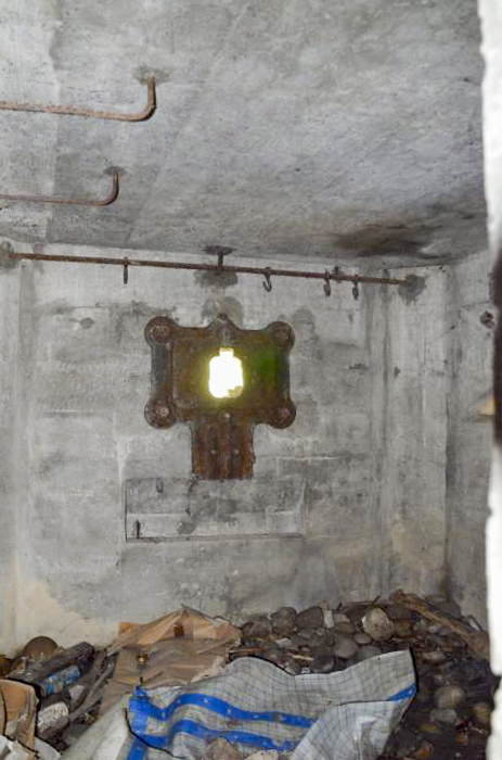 Ligne Maginot - HABERHAEUSER 1 - (Blockhaus pour arme infanterie) - Chambre de tir, comprenant une plaque de blindage particulière pour mitrailleuse. Remarquez l'absence de la plate-forme en béton pour la mitrailleuse. Au plafond on distingue des barres en acier avec des crochets de suspension. - D. Froehly