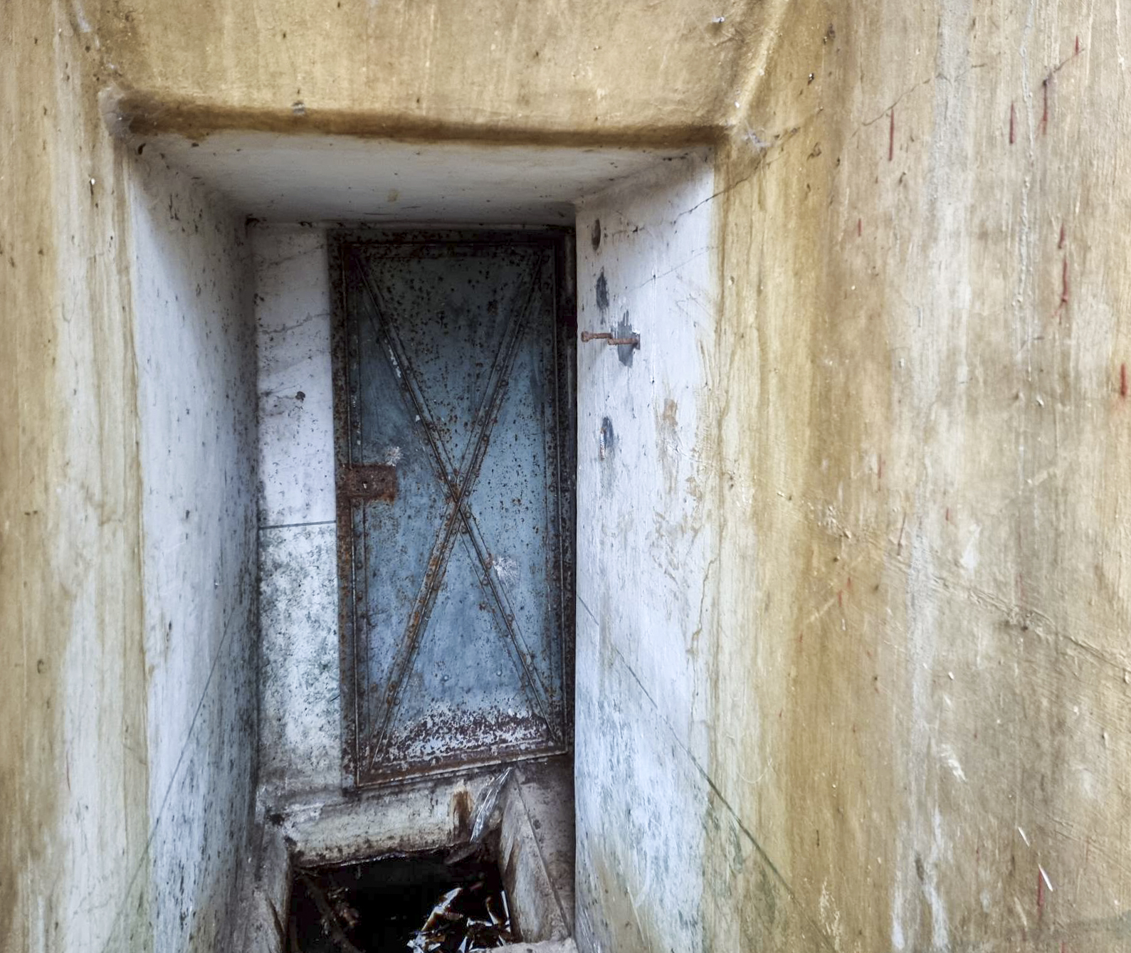 Ligne Maginot - 21M - (Chambre de coupure) - Couloir intérieur : la porte du local téléphonique, l'évacuation des eaux, et l'emplacement du boîtier de connexion sur le mur de droite. - DK_Antoine4