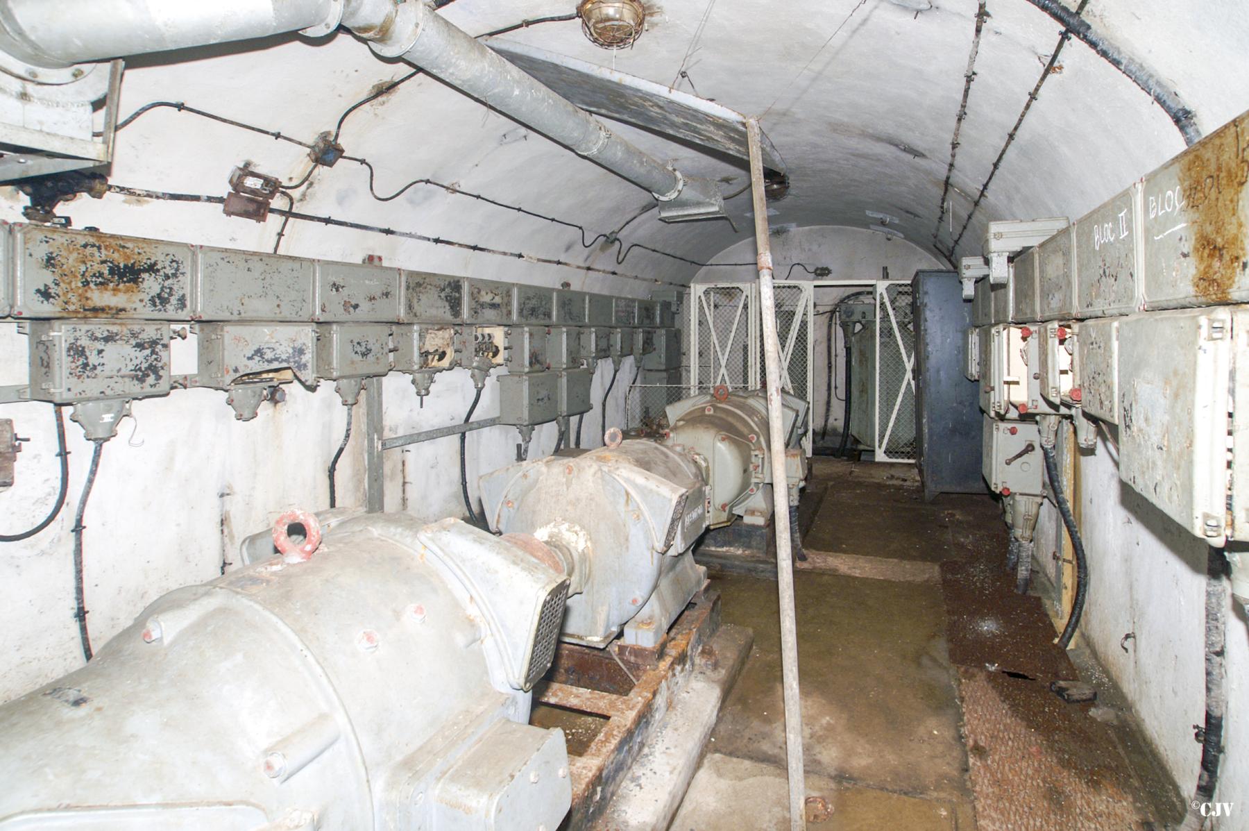 Ligne Maginot - BREHAIN - A6 - (Ouvrage d'artillerie) - La station électrique des avants
Les convertisseurs pour l'alimentation des tourelles au premier plan et les transformateurs abaisseurs (3000V - 400V) au second plan - Lia VERMEULEN