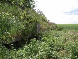 Ligne Maginot - SAINT WALFROY (4° BON - 155° RIF) - (PC de Quartier) - L'arrière du bâtiment, dégagé de l'empierrement devant le protéger, laisse apparaître la cunette et le regard permettant de recueillir les eaux de pluie tombant sur la dalle.
