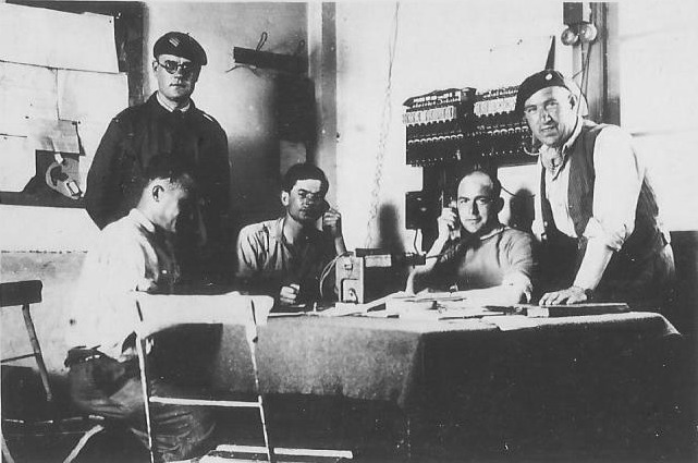 Ligne Maginot - SOULTZ SOUS FORET - (Infrastructure ferroviaire) - Soultz-sous-Forêts, 1939-40. Le poste de régulation du trafic.
Le sous-officier debout à gauche est le chef régulateur, le personnage assis au centre étant le Lt Durupt, responsable du réseau de communications, l’autre homme au téléphone, le Lt Guérin, chef des ateliers de réparations  - Edouard-Roger Basset