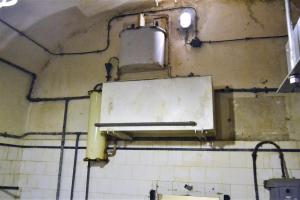 Ligne Maginot - GALGENBERG - A15 - (Ouvrage d'artillerie) - La cuisine troupe
Installation carbone-chlore de traitement de l'eau. La partie supérieure est le système de dosage du chlore. Une fois le mélange fait, celui ci passe au travers du filtre à charbon actif (tube sur la gauche de la photo) puis est stocké dans la citerne de couleur blanche en bas de la photo