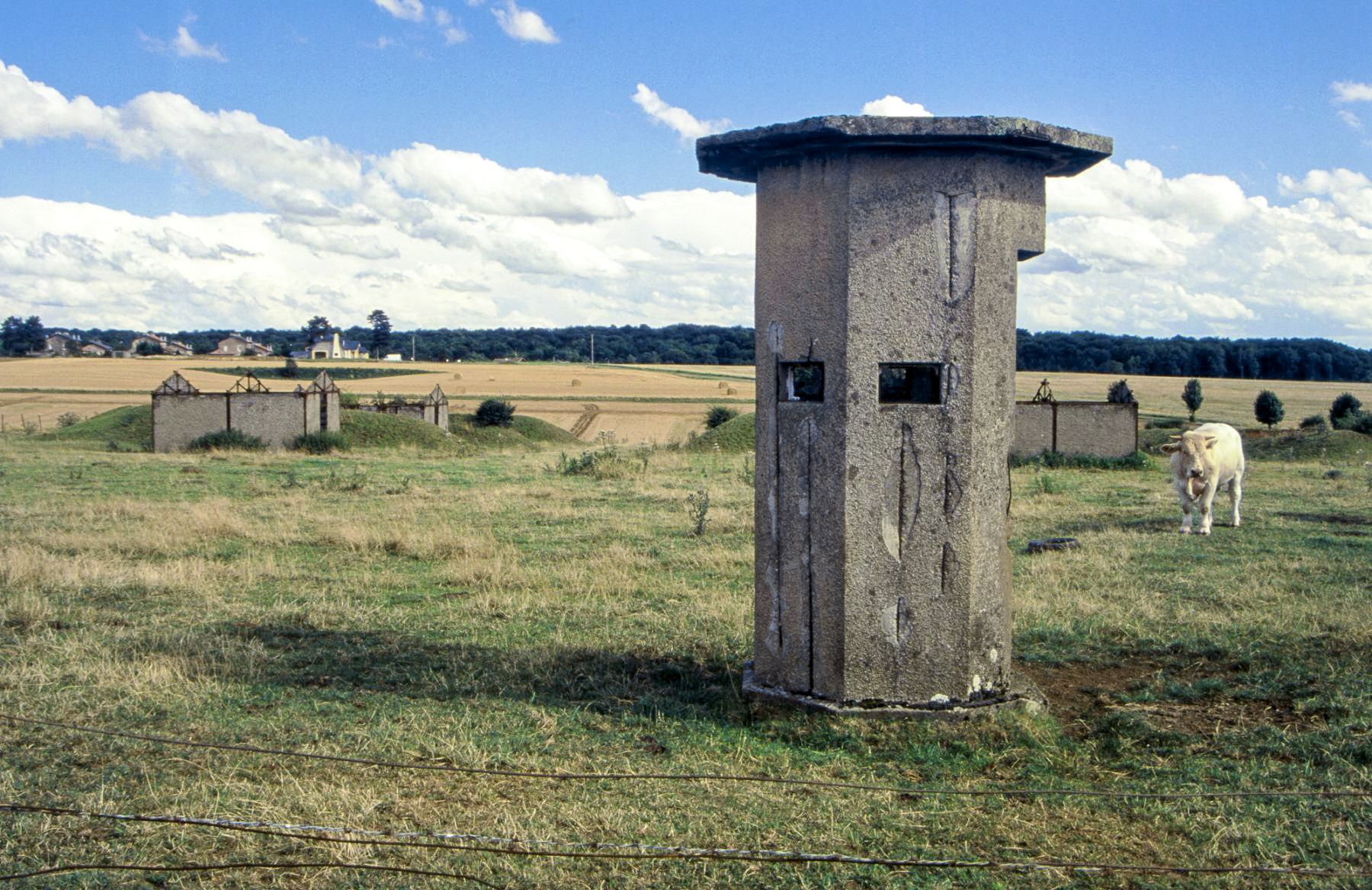Ligne Maginot - MORFONTAINE - (Dépôt de Munitions) - Entrée du dépôt en 1999. On aperçoit au second plan les bâtiments du dépôt, entre leurs alvéoles. 
La cité des cadres du camp de Morfontaine est visible à l'horizon. - Michel Teiten
