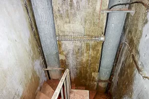 Ligne Maginot - LAVOIR - (Ouvrage d'artillerie) - Bloc 1 
Escalier entre les étages 
Noter le radiateur entre les deux conduites