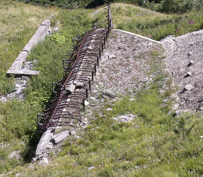 Ligne Maginot - LAVOIR - (Ouvrage d'artillerie) - Grille défensive de l'entrée des hommes
Son pliage est du à la poussée de la neige/glace du fait de la pente en arrière.
Les piquets renforcés par un jambage se sont brisés juste au-dessus des jambages de renfort, et l'ensemble à plié en avant - JOLAS, Jean-Michel